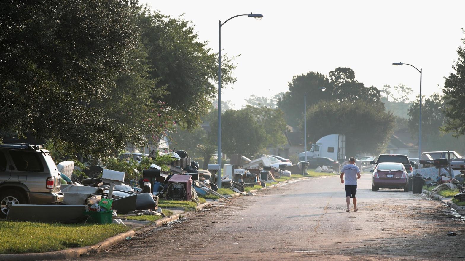 A person walks down a street as residents begin the process of cleaning up the damage to their property after torrential rains caused widespread flooding during Hurricane and Tropical Storm Harvey on September 1, 2017 in Houston, Texas. (Photo: Scott Olson, Getty Images)
