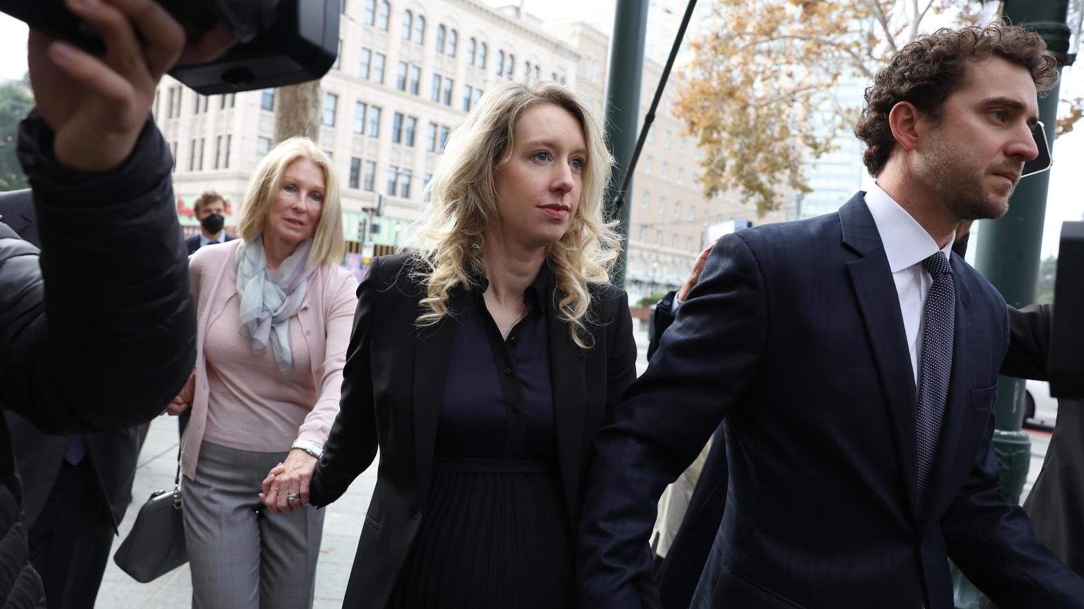 Theranos CEO Elizabeth Holmes, centre, walking into court surrounded by her mother Noel Holmes and partner Billy Evans. Holmes was sentenced in San Jose Federal Court Nov. 18. (Photo: Justin Sullivan, Getty Images)
