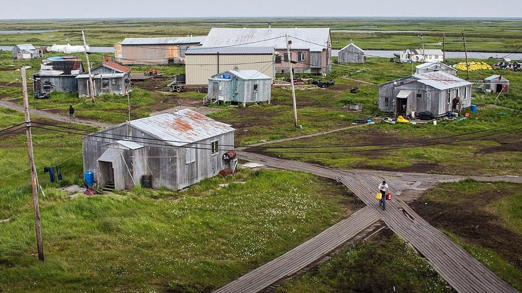 People walk down the elevated, raised wooden footpaths - created so people don't sink into the melting permafrost - on July 5, 2015 in Newtok, Alaska. (Photo: Andrew Burton, Getty Images)