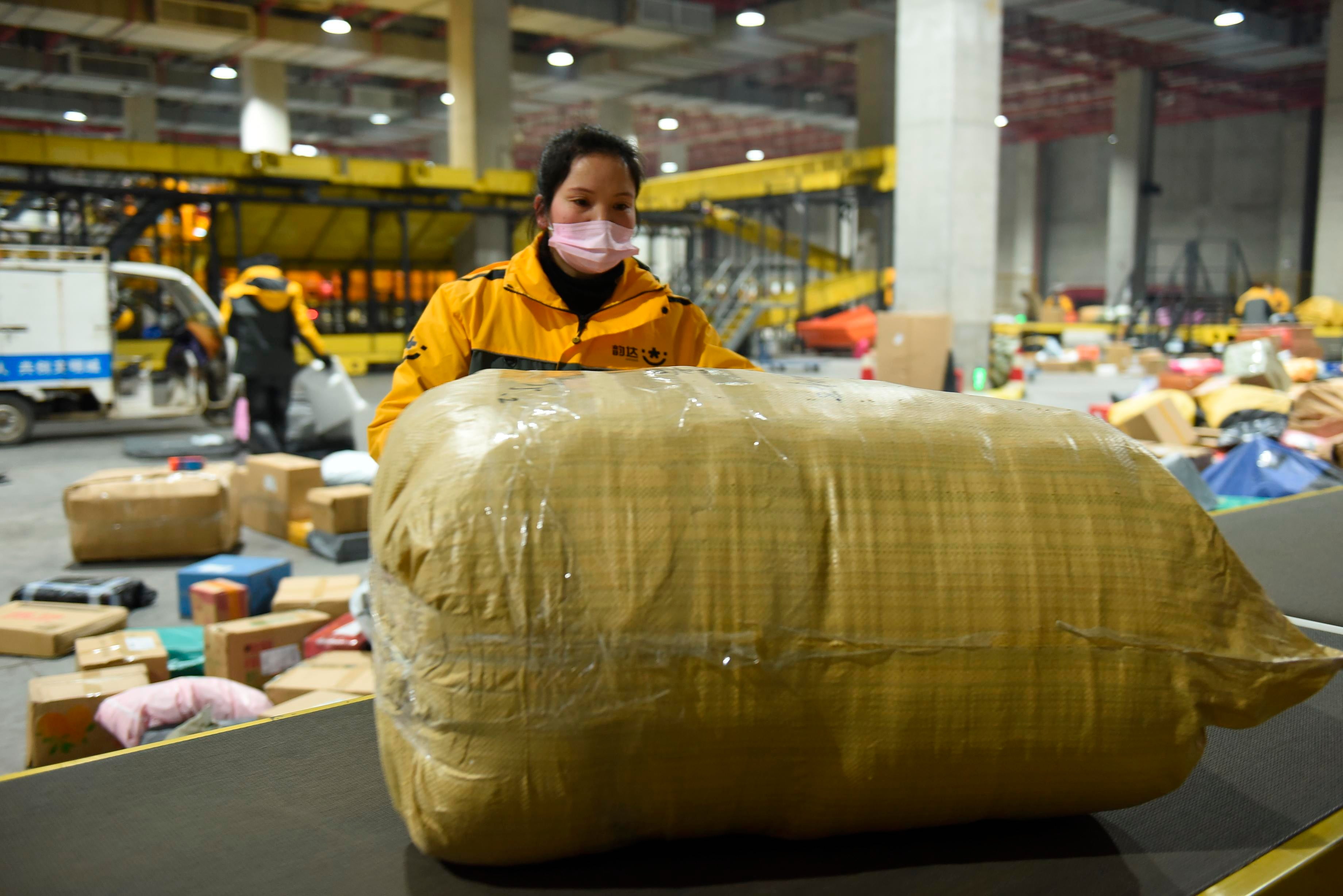 As the Double 12 shopping carnival is coming, workers are busy sorting  express packages on the assembly line in the E-commerce Logistics  Industrial Park of Donghai County, Lianyungang City, east China's  Jiangsu Province, December 7, 2022. (Photo: Imaginechina, AP)