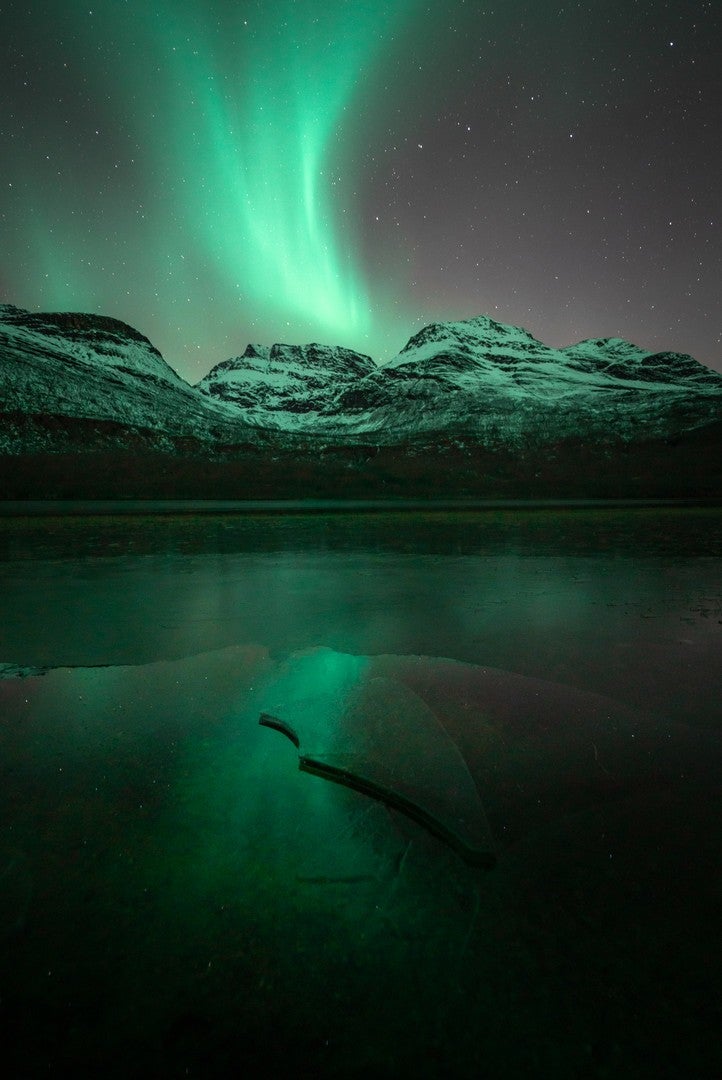 A pale green aurora over a mountain. (Photo: Lena Pettersen)