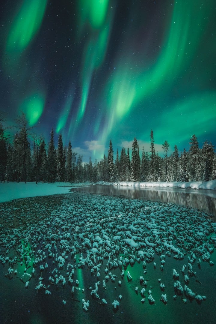 A frozen water body beneath the aurora in Finland. (Photo: Itai Monnickendam)
