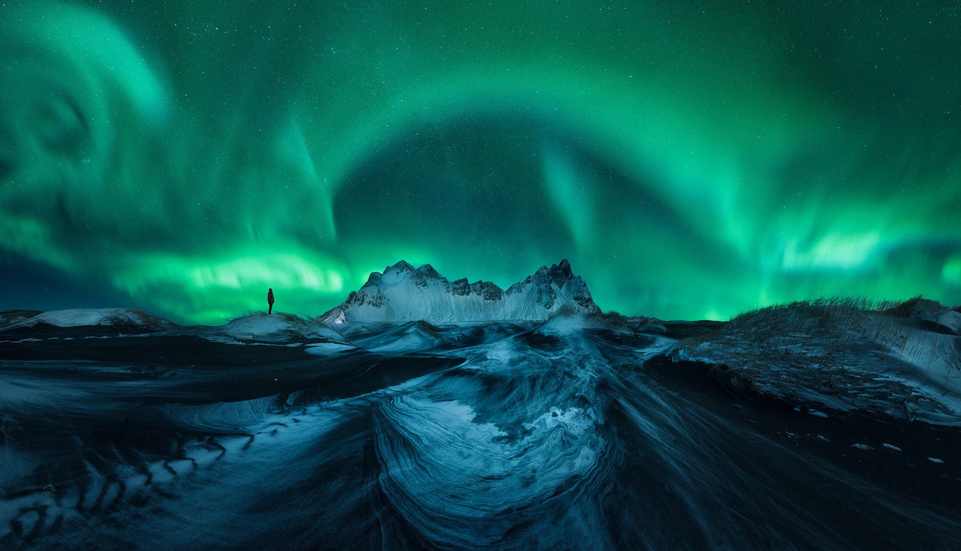 A person silhouetted under the Northern Lights. (Photo: Asier López Castro)