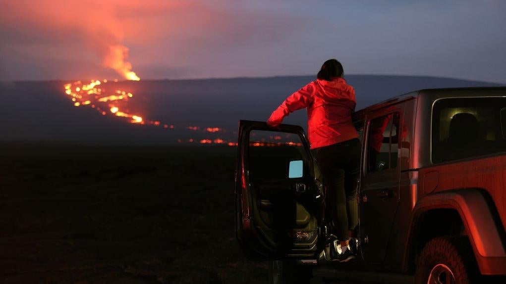 A woman watches the eruption of the Mauna Loa volcano on December 04, 2022 near Hilo, Hawaii. (Photo: Justin Sullivan, Getty Images)