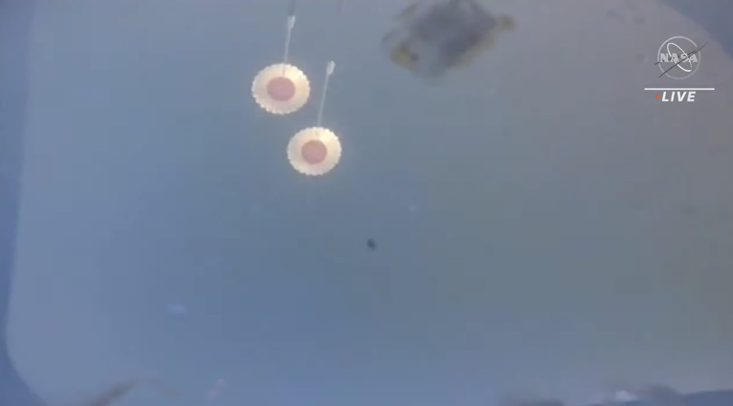 A view of the drogue parachutes shortly after deployment.  (Screenshot: NASA TV)