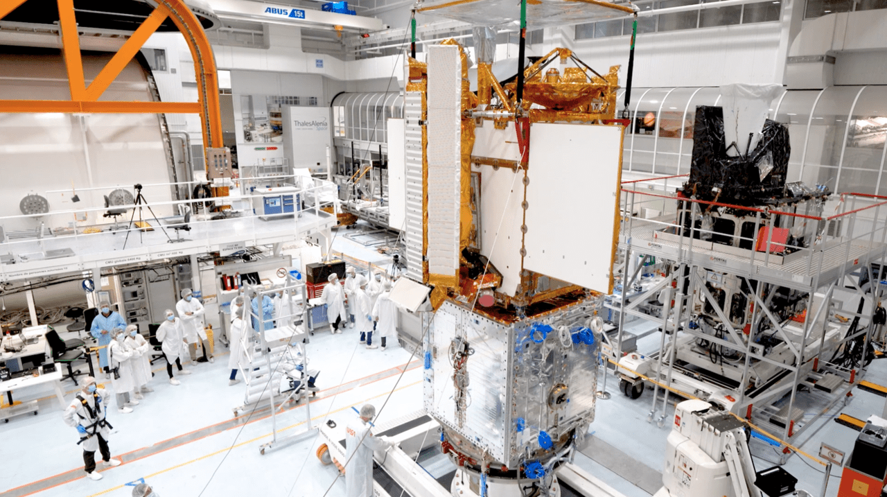 Engineers integrating parts of the SWOT satellite into one in a Thales Alenia Space clean room facility in Cannes, France. (Photo: NASA)