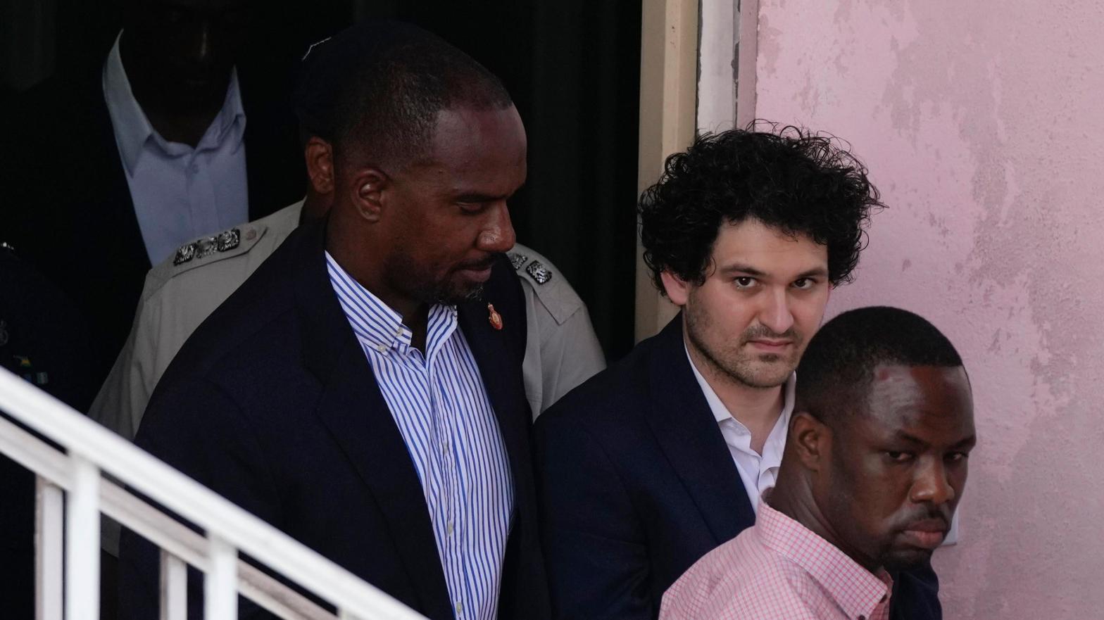 Bankman-Fried was escorted out of Bahamas Magistrate court Monday during a helter-skelter court proceeding over whether he would contest extradition. SBF's return to the U.S. could come as soon as Wednesday, according to multiple reports. (Photo: Rebecca Blackwell, AP)