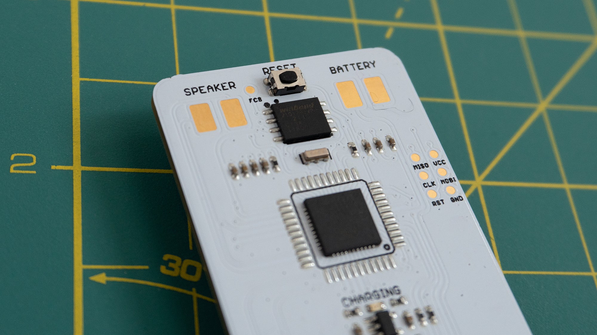 The back of the Arduboy Mini features exposed contacts for attached a rechargeable battery and a speaker. (Photo: Andrew Liszewski | Gizmodo)