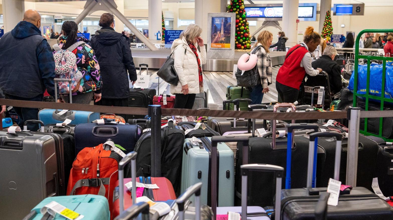 Travellers search through mountains of luggage at the baggage claim at  Chicago Midway International Airport on Dec. 26, 2022, in Chicago.   (Photo: Tyler Pasciak LaRiviere/Chicago Sun-Times, AP)
