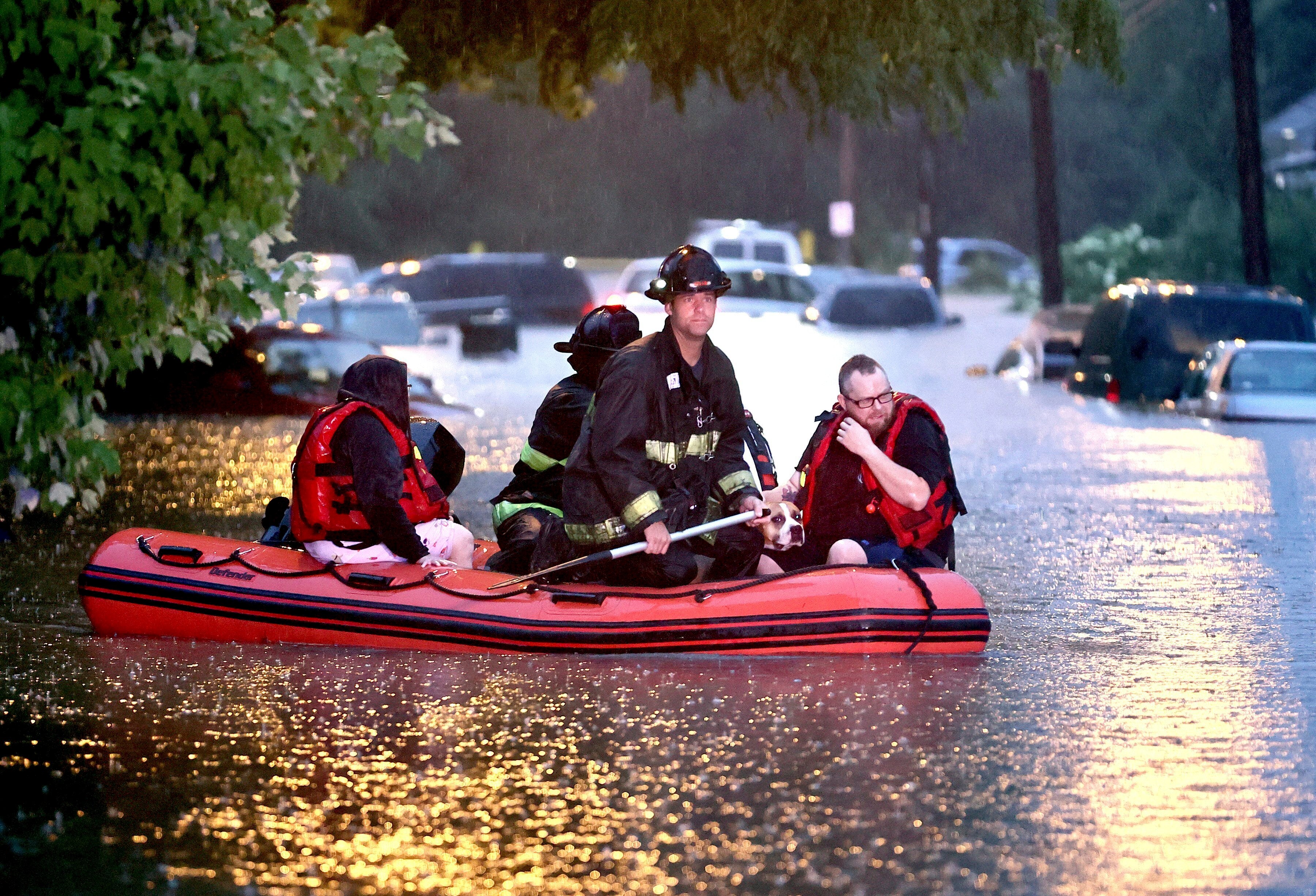 Steven Bertke and his dog Roscoe are taken to dry land by St. Louis firefighters who used a boat to rescue people from their flooded homes on Hermitage Avenue in St. Louis on Tuesday, July 26, 2022. (Photo: David Carson/St. Louis Post-Dispatch, AP)