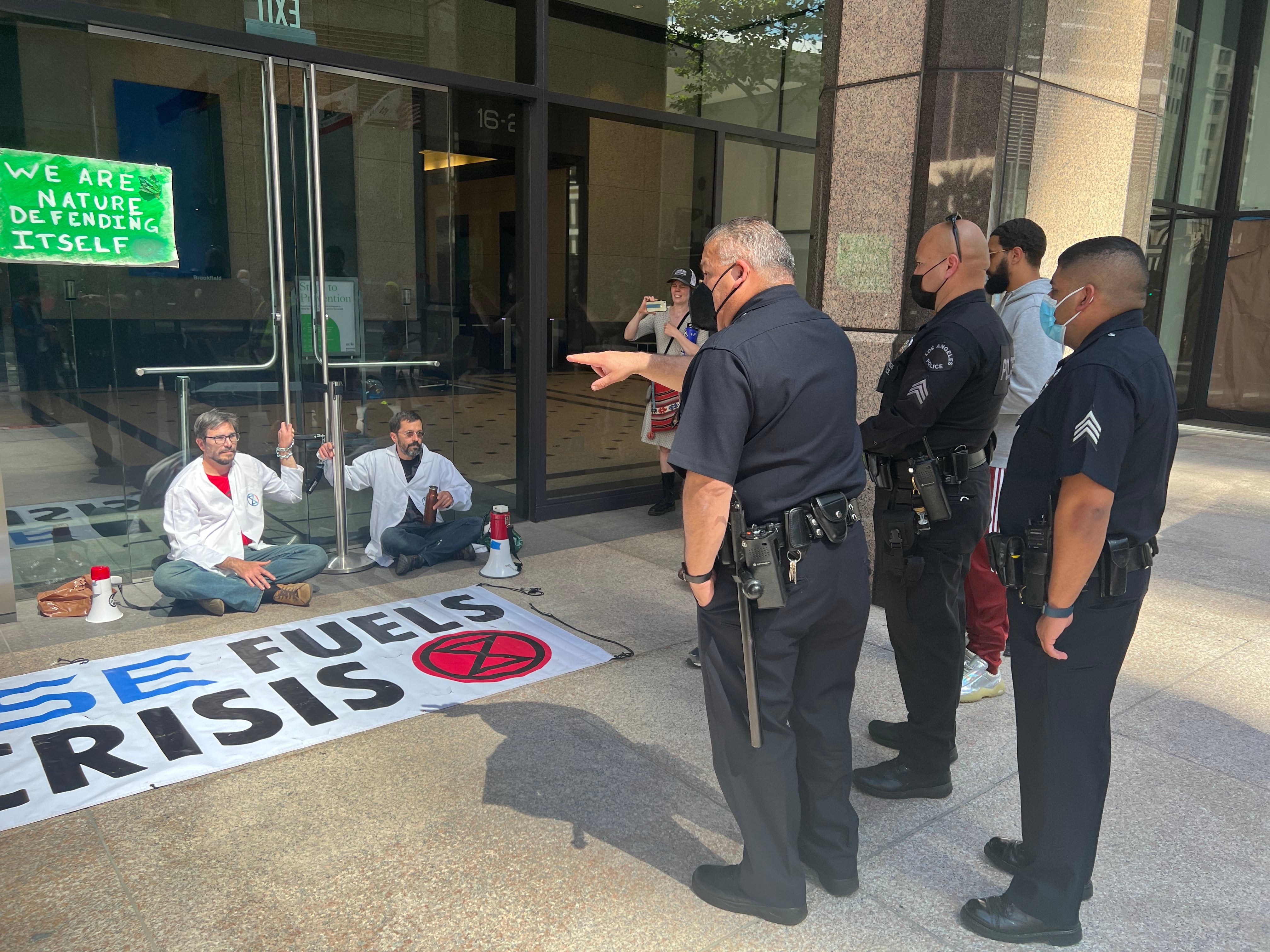 Police point at protestors chained to Chase Bank.  (Photo: Brian Emerson)
