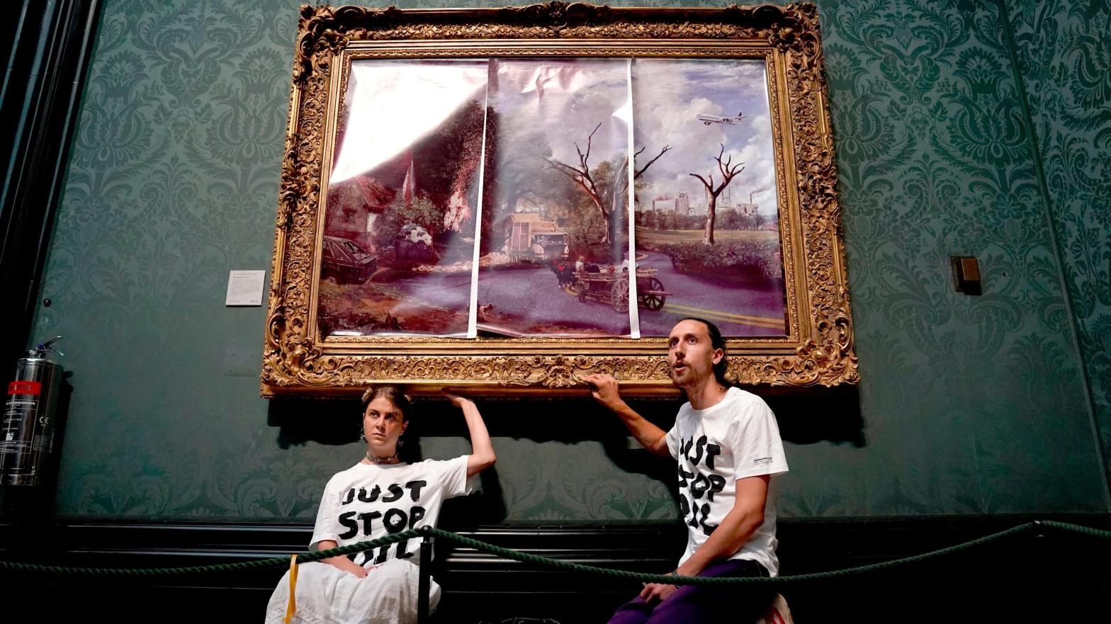 Protesters from Just Stop Oil climate protest group glue their hands to the frame of John Constable's The Hay Wain after first having covered the painting with their own picture at the National Gallery, London, on December 20, 2022.  (Photo: Press Association, AP)