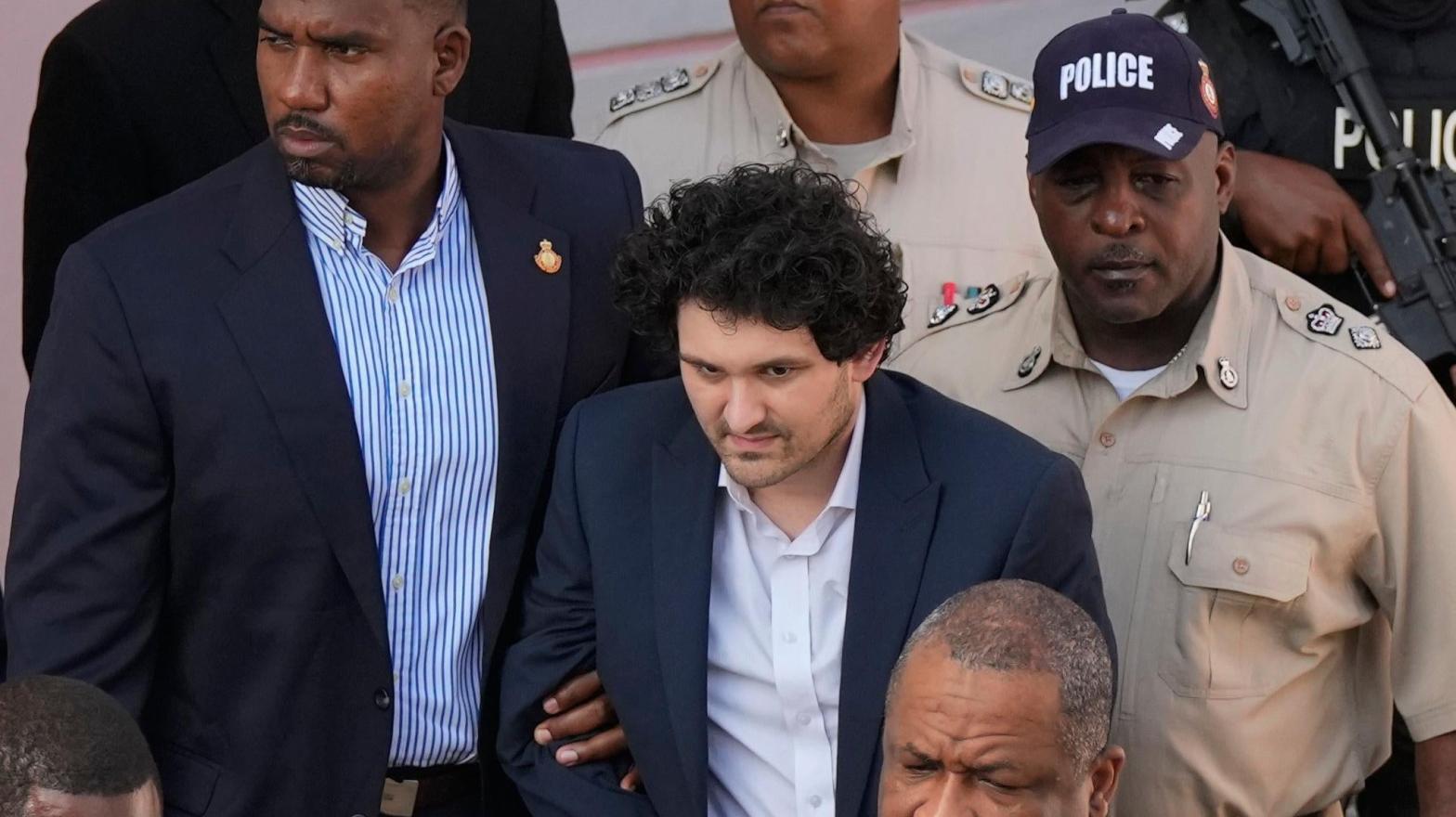 FTX founder Sam Bankman-Fried, centre, is escorted out of Magistrate Court following a hearing in Nassau, Bahamas on Dec. 19, 2022. (Photo: Rebecca Blackwell, AP)