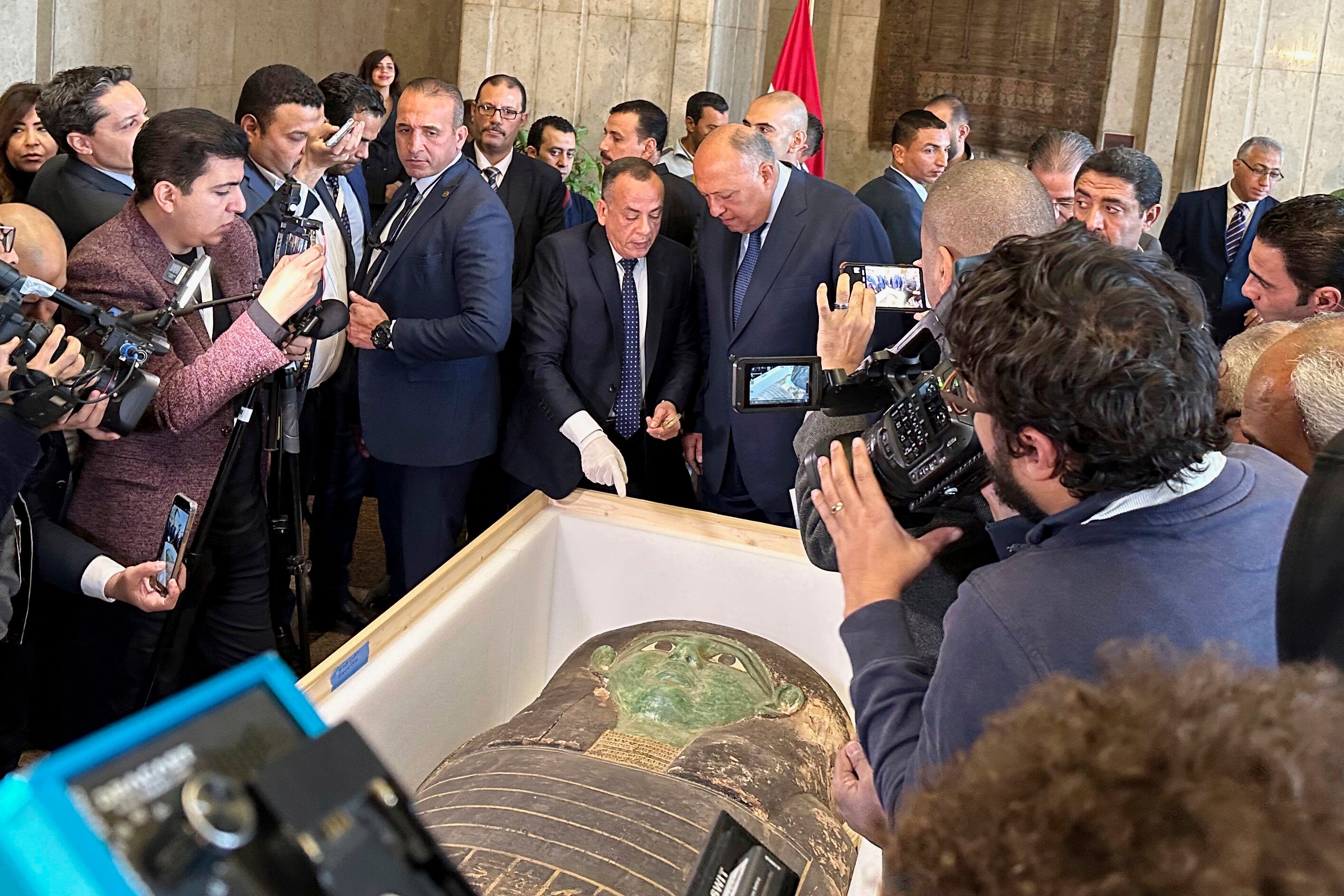 Egyptian officials with the repatriated sarcophagus. (Photo: AP / Mohamed Salah)