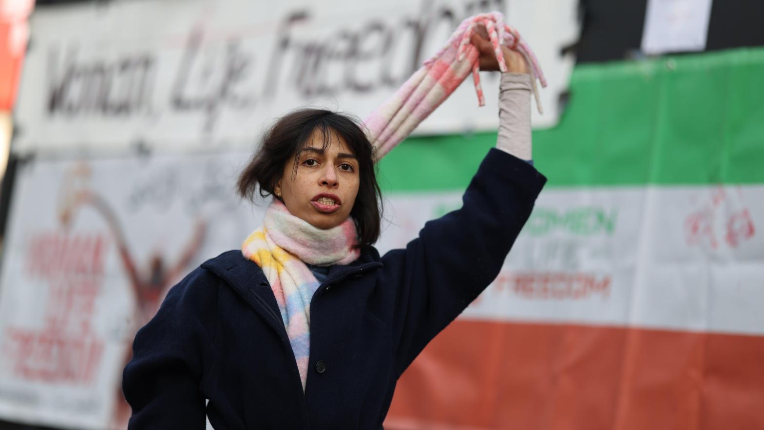 A demonstrator holds a scarf like a noose around her neck during a One Law for All dance protest at Piccadilly Circus on December 17, 2022 in London, England (Image: Hollie Adams, Getty Images)