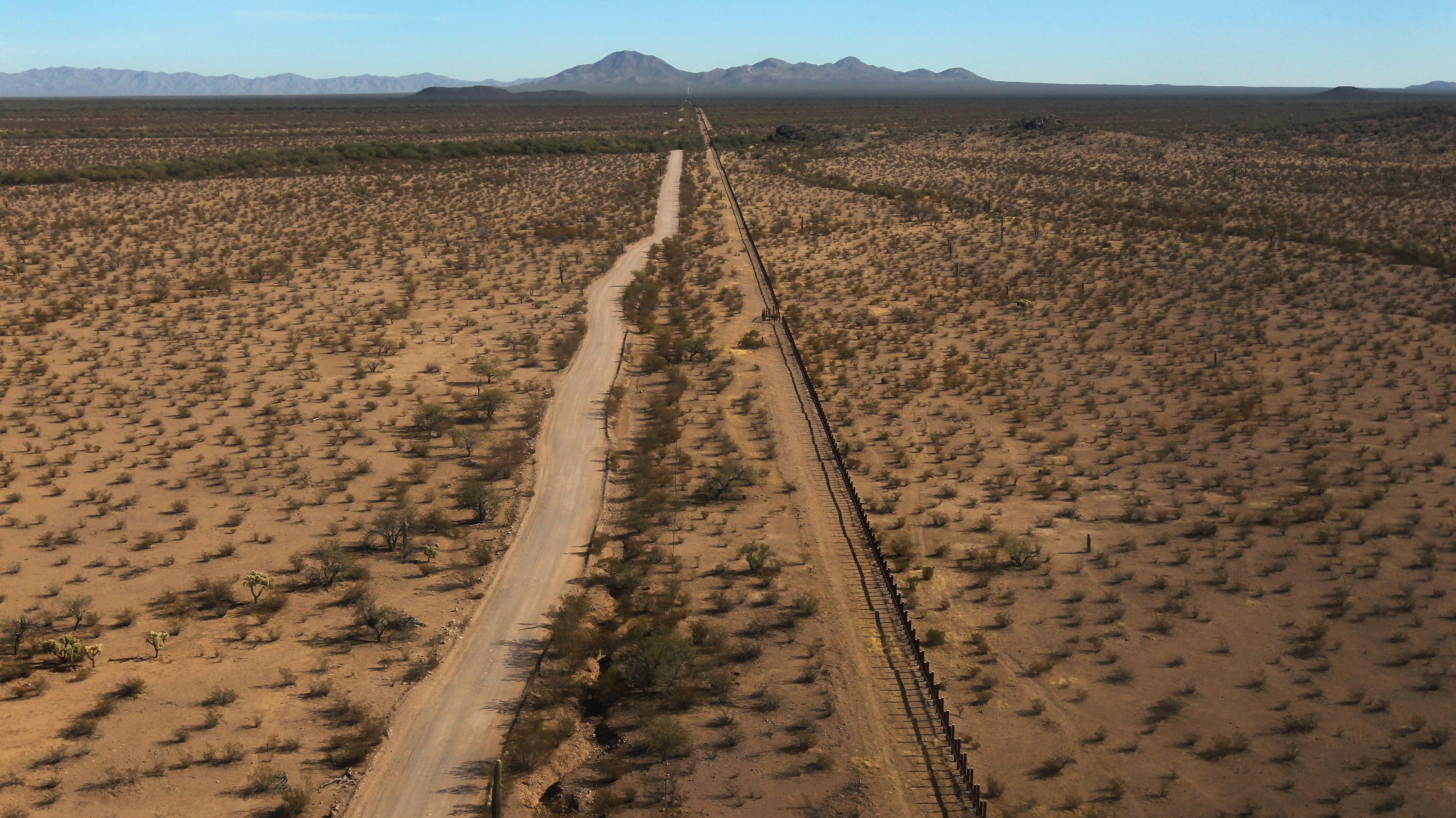 As seen from the air, the U.S.-Mexico border fence (U.S.-L) stretches through the Sonoran Desert on December 9, 2010 in the Tohono O'odham Reservation, Arizona.  (Photo: John Moore, Getty Images)