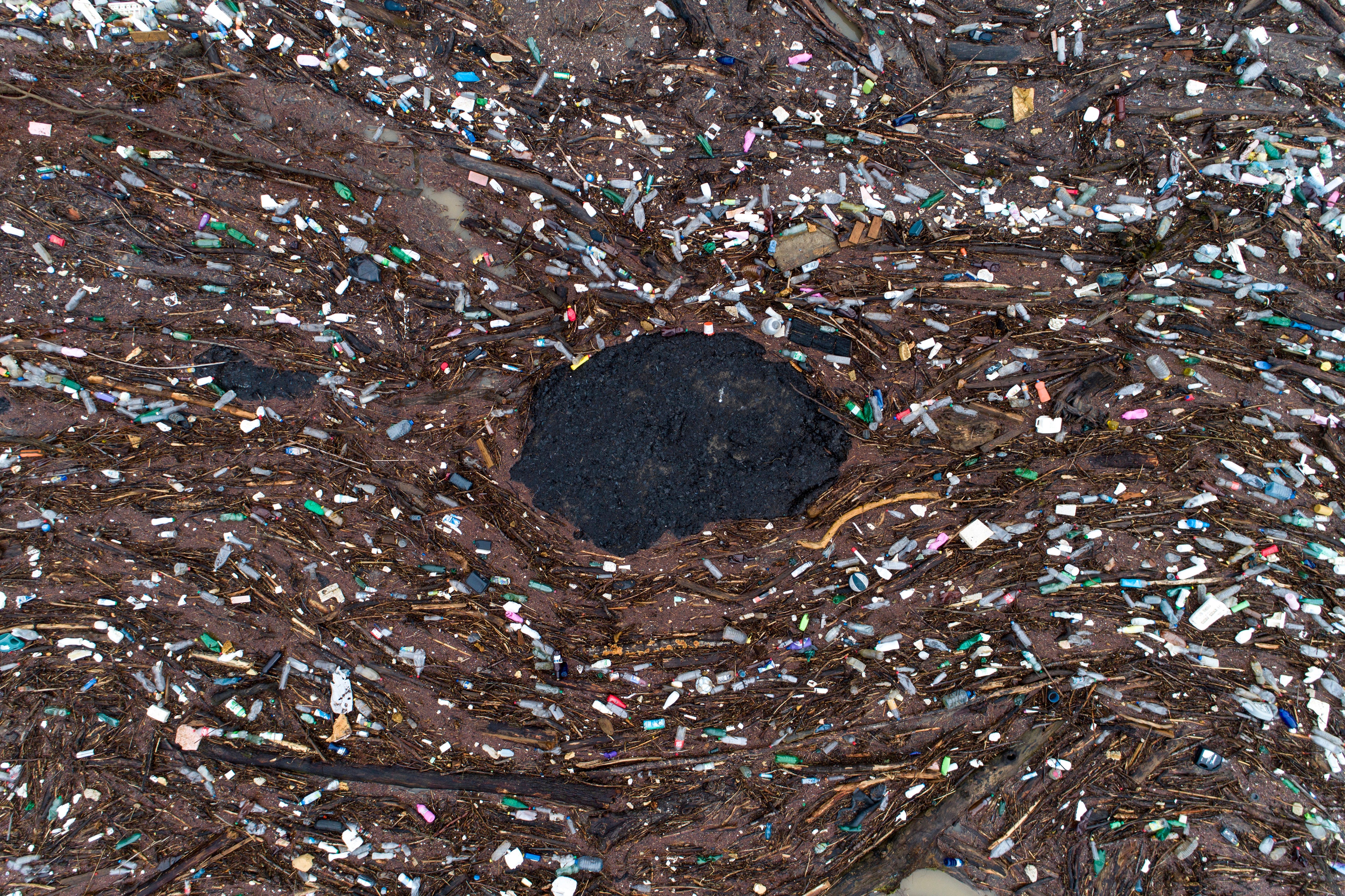 Swirls of plastic pollution amidst driftwood. (Photo: Armin Durgut, AP)