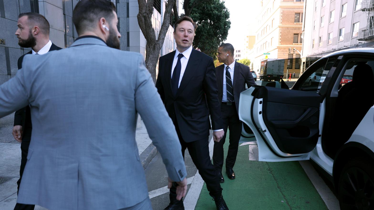 Elon Musk stands by his Tesla car after leaving the courthouse during an ongoing legal dispute surrounding his supposed 2018 plans to take Tesla private. It's just one of many scandals surrounding the company that puts a damper on Tesla's record profits. (Photo: Justin Sullivan, Getty Images)