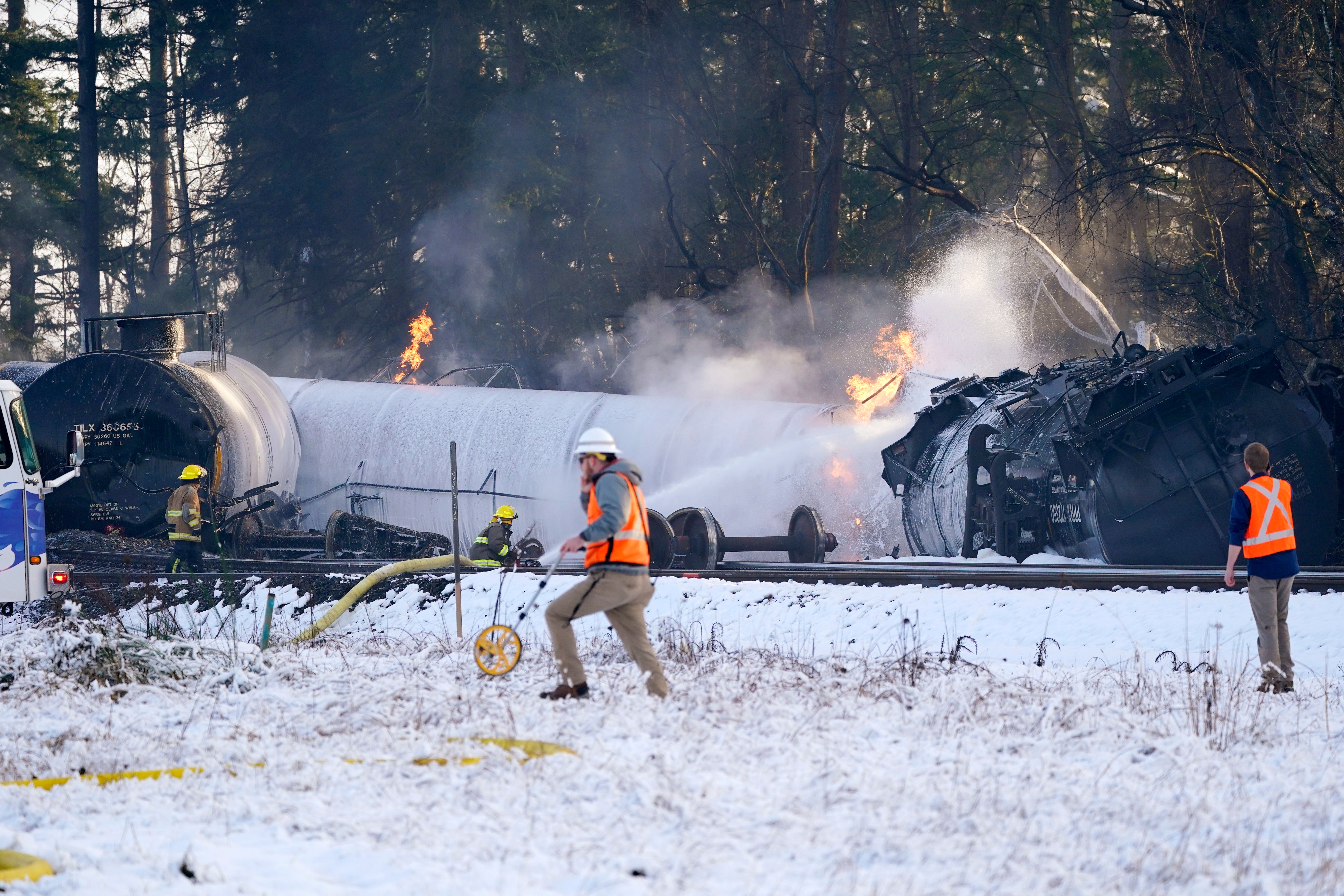 A firefighter sprays foam on a burning rail car. (Photo: Elaine Thompson, AP)