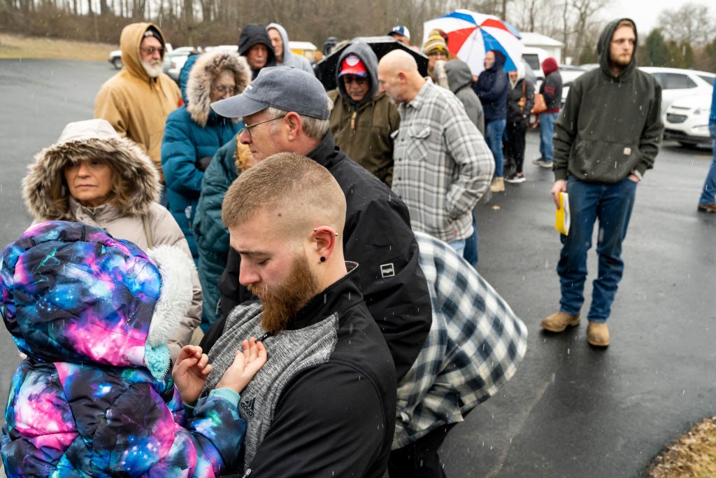 Neil Figley holds his daughter, Harlie, as they wait in line at the Norfolk Southern Assistance Centre to collect a $US1,000 ($1,388) check and get reimbursed for evacuation expenses on on February 17, 2023.  (Photo: Michael Swensen, Getty Images)