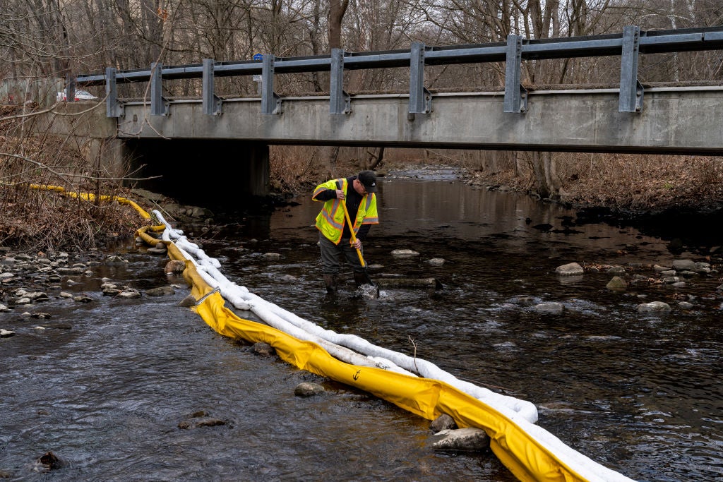 Ron Fodo, Ohio EPA Emergency Response, looks for signs of fish and agitates the water in Leslie Run creek to check for chemicals that have settled at the bottom.  (Photo: Michael Swensen, Getty Images)