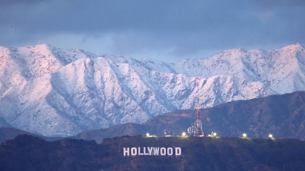 The Hollywood sign stands in front of snow-covered mountains after another winter storm hit Southern California on March 01, 2023 in Los Angeles, California. (Photo: Mario Tama, Getty Images)