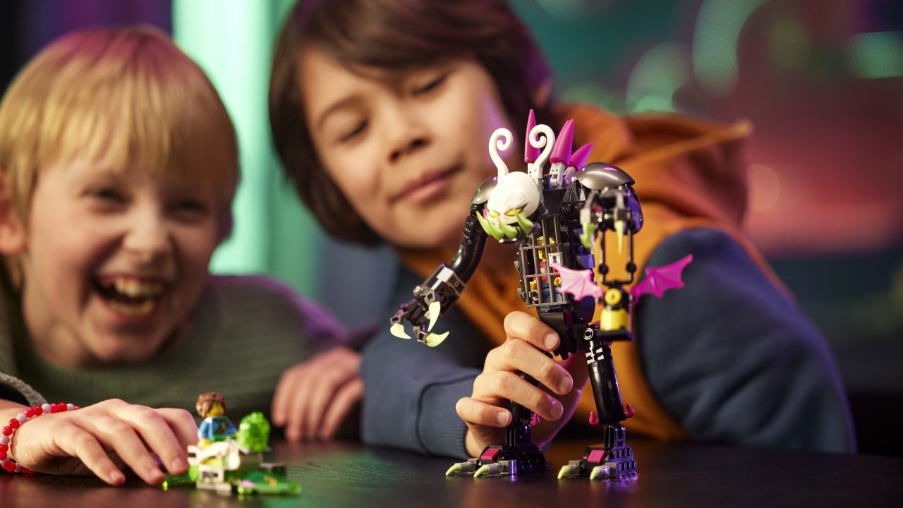 Two kids playing with a villain from Lego Dreamzzz. One of the children looks very excited.