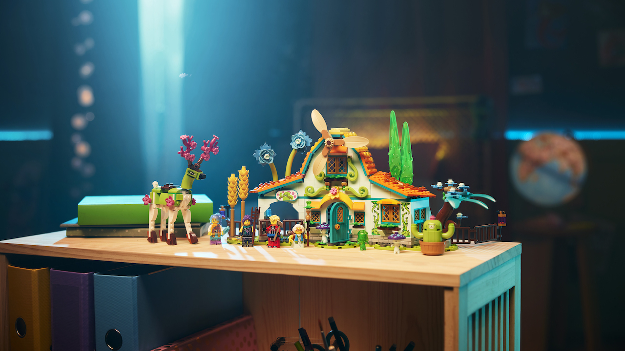 A lego Dreamzzz set on a table of a pastel coloured stable with some weird animals covers in flowers