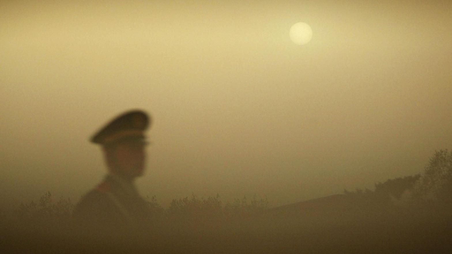 A police officer patrols Tiananmen Square during a dust storm on April 18, 2006 in Beijing, China.  (Photo: China Photos, Getty Images)