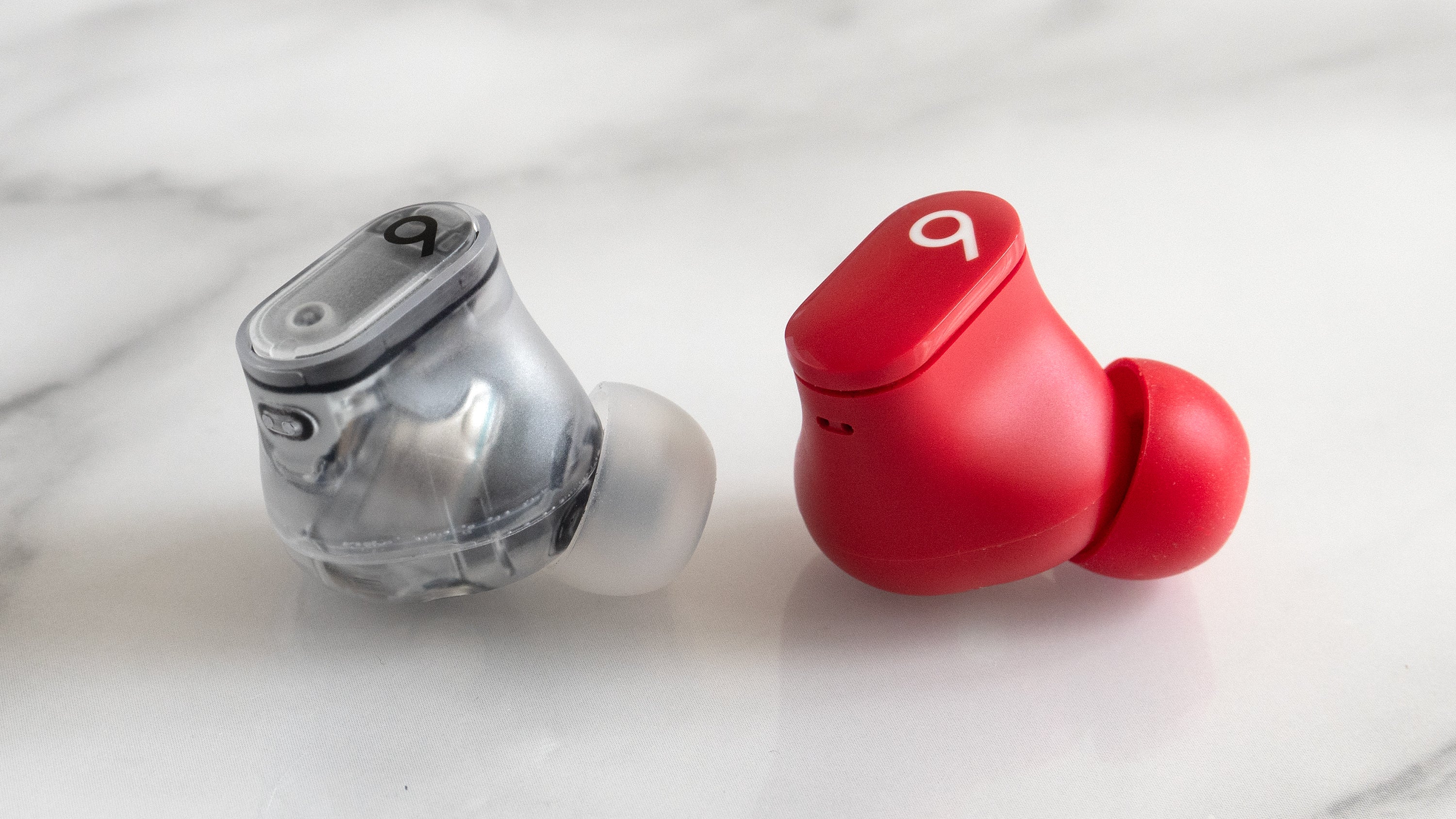 Users of the original Beats Studio Buds (right) will appreciate the upgraded design of the shortcut button on the Beats Studio Buds + (left), which is harder to accidentally press while handing the earbuds. (Photo: Andrew Liszewski | Gizmodo)