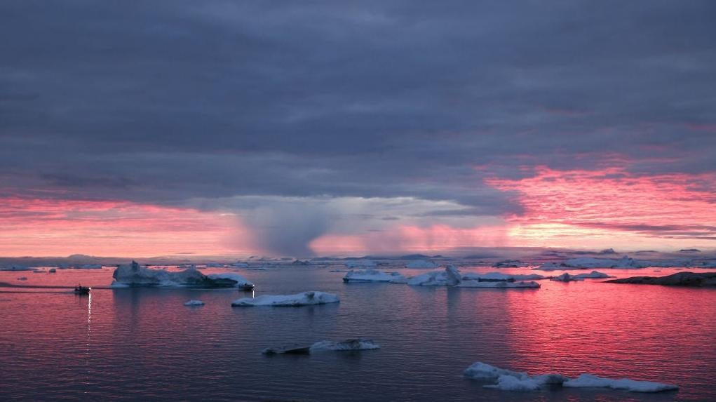 The sun sets as rain falls beyond floating ice and icebergs in Disko Bay above the Arctic Circle on September 04, 2021 in Ilulissat, Greenland. (Photo: Mario Tama, Getty Images)