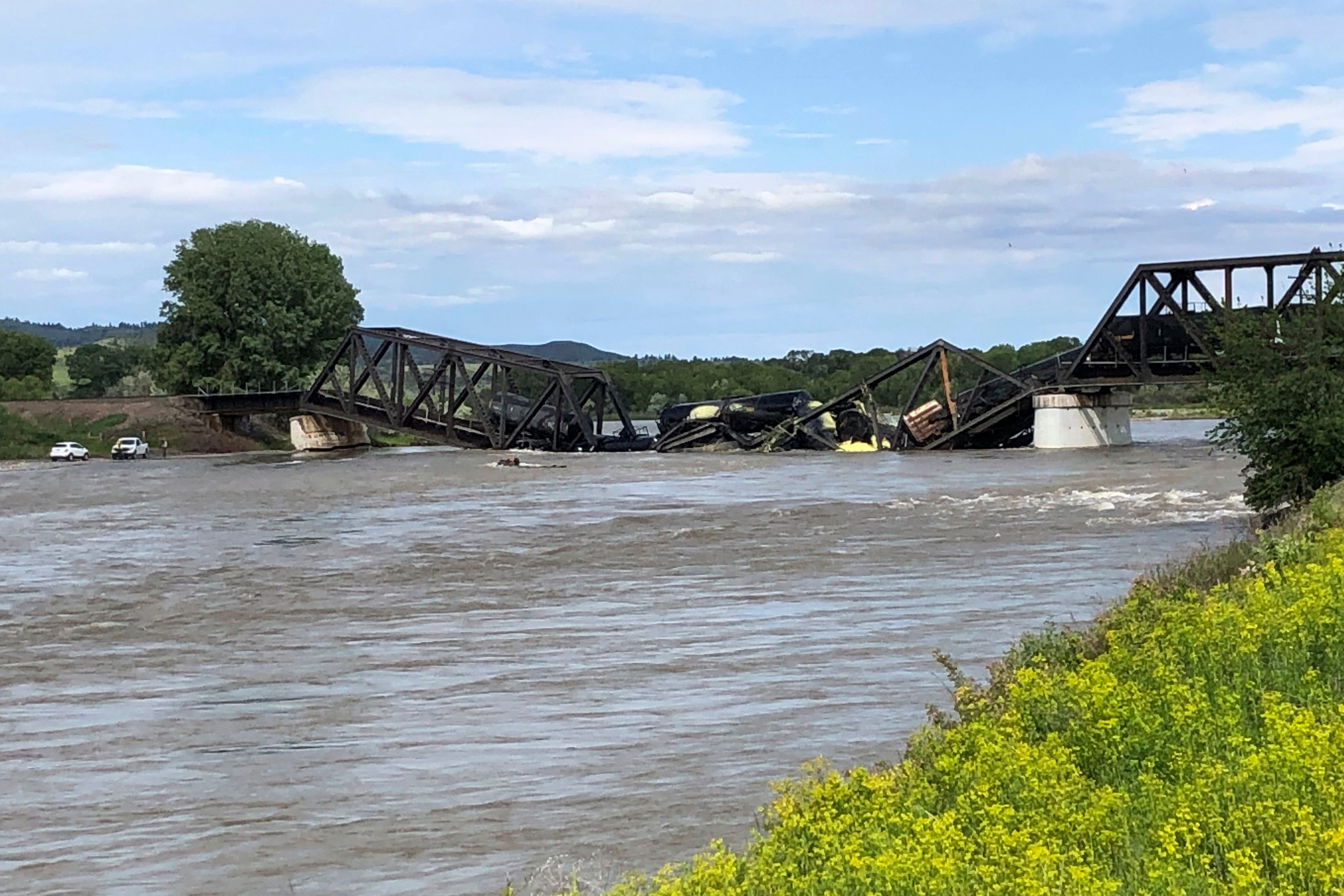 Several train cars are immersed in the Yellowstone River after a bridge collapse near Columbus, Montana, on Saturday, June 24, 2023. (Photo: Matthew Brown, AP)