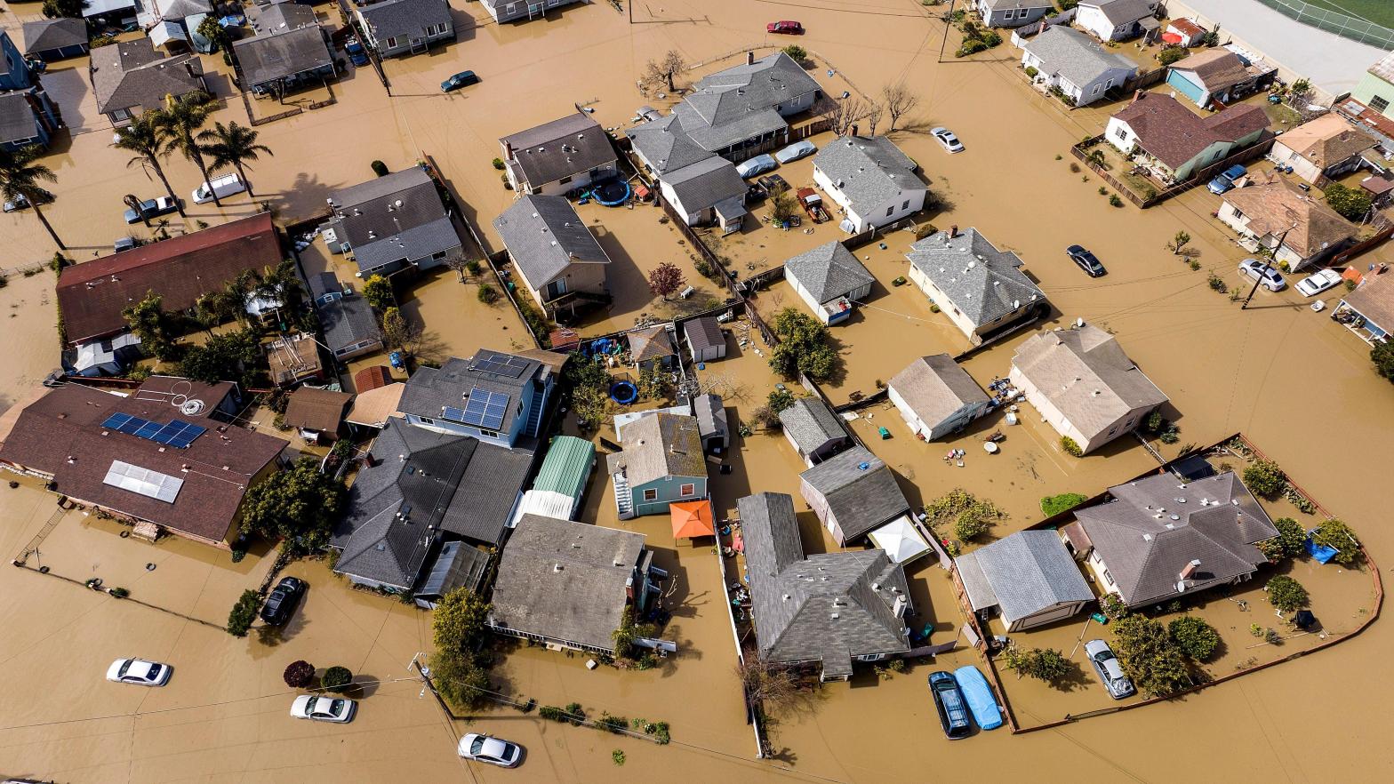 Floodwaters surround homes and vehicles in the community of Pajaro in Monterey County, California on March 13, 2023. (Photo: Noah Berger, AP)