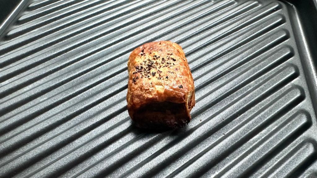Perfectly cooked sausage roll on a grill tray