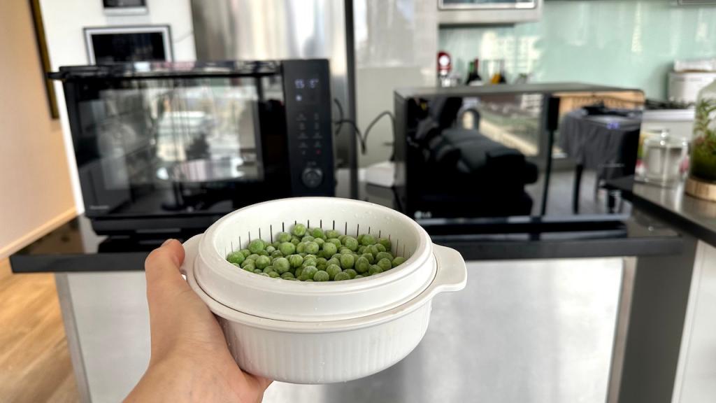 Container of peas about to go into a microwave