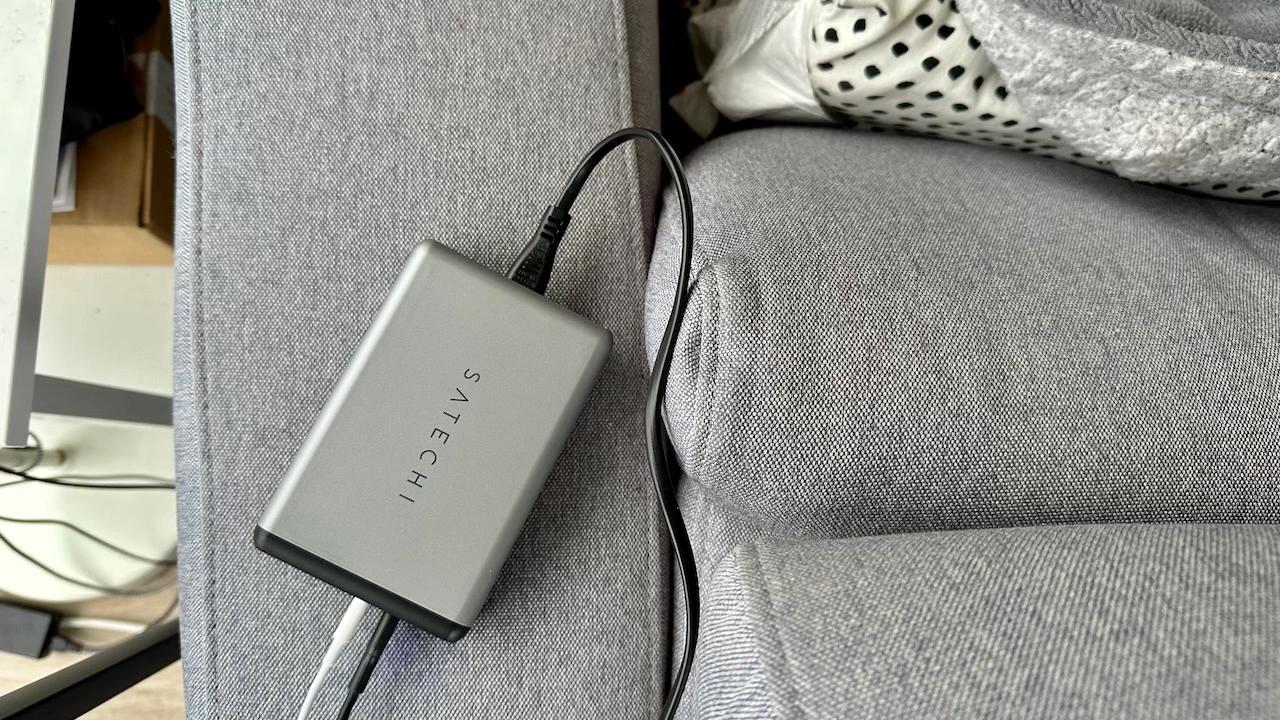 A GaN charger on a couch arm