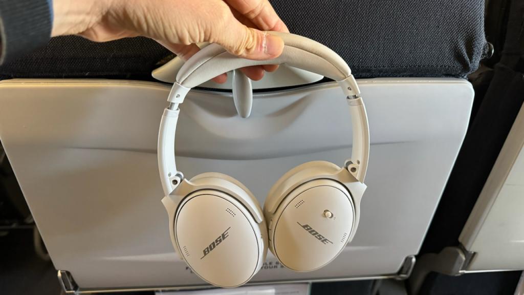 Holding up a pair of Bose headphones